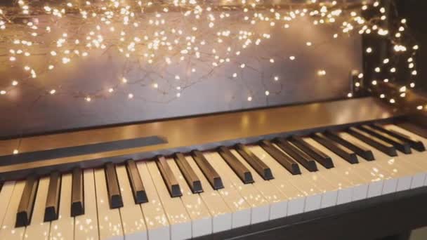 Hermoso sintetizador con decoraciones navideñas. Teclas de sintetizador de primer plano. Sintetizador con luces de Año Nuevo. — Vídeo de stock