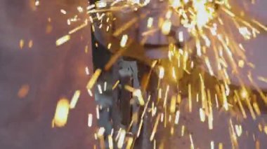 Parçalama çarkının bir parçasını öğütmekten kıvılcımlar çıkıyor. Değirmen çarkında metal bir parça işleniyor. Parlak kıvılcımlar metal bir parçayı makinelemekten.