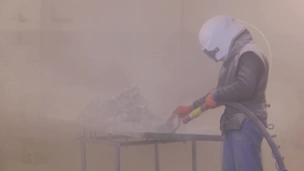 Zandstraal metalen onderdelen. De man is het detail aan het zandstralen. Zandstraalpistool — Stockvideo