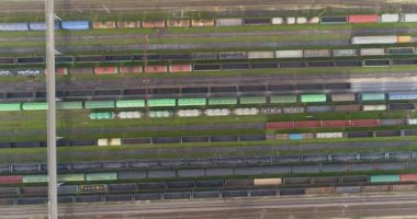 Güneşli havada demiryolu kavşağı, üst manzara. Tren istasyonunun üst manzarasındaki yük trenleri. Demiryolu kavşağındaki yük trenleri