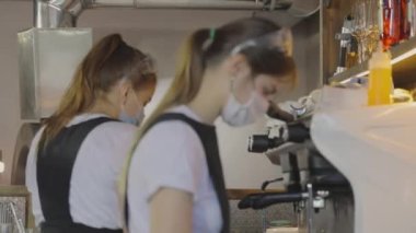 Maskeli bir barista kahve yapar, insanlar maske takar, karantinadan sonra çalışır. Kahve yapıyorum.