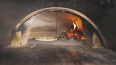 Yanan bir fırında pizza pişirmek. Tahtadan yapılmış pizza pişirme.