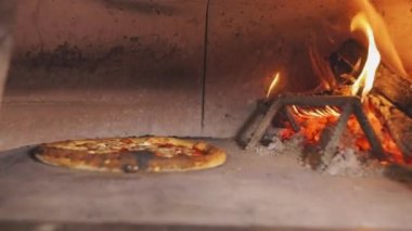 Yanan bir fırında pizza pişirmek. Tahtadan yapılmış pizza pişirme.