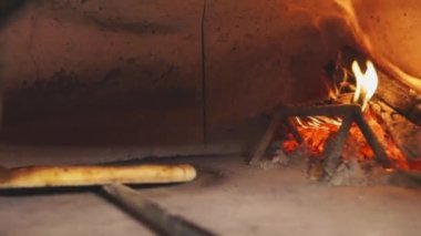 Yanan bir fırında pizza pişirmek. Tahtadan yapılmış pizza pişirme.