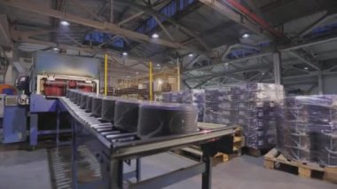 Modern bir konveyörde kabloyla makaraları paketlemek, otomatik makaraları kabloyla sarmak, fabrikada modern otomatik taşıyıcı.