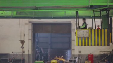 Fabrikada çalışma, fabrikada ışın vinci, ışın vincini kontrol eden bir kadın.