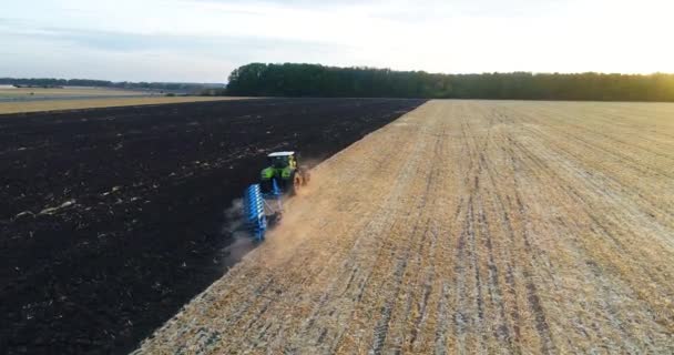 Tractor werkt in het veld bovenaanzicht. Vliegen over de trekker in het veld. De trekker ploegt het veld. — Stockvideo