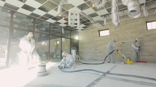 Moagem de superfície de concreto. Construtores num estaleiro. Os construtores estão a polir o chão com equipamento especial. — Vídeo de Stock