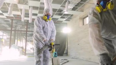 Beton yüzey öğütme. İnşaat alanındaki inşaatçılar. İnşaatçılar zemini özel ekipmanlarla parlatıyorlar..