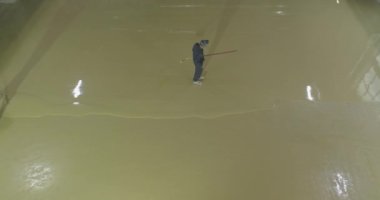 Kendi kendine döşeme döşemesi. Geniş bir alanda kendi kendine döşeme zemini döşeyen bir işçi, bir fabrika atölyesine kendi kendine döşeme döşedi.