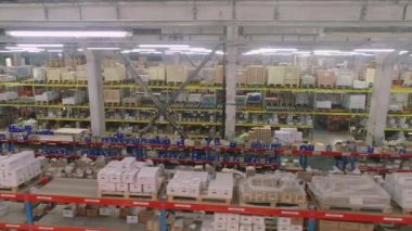 Büyük bir depodaki raflar boyunca genişlet. Stoklarında mal olan raflar. Modern depo. Endüstriyel iç