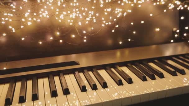 Synthesizer with New Years lights. Beautiful synth with Christmas decorations. Close-up synthesizer keys — Stock Video