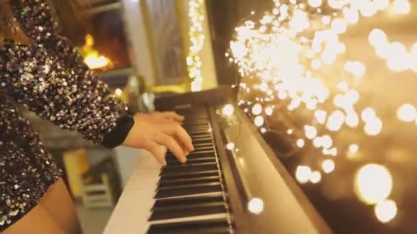 Дівчина грає синтезатор. Крупним планом руки грають у синтезатор. Синтезатор з різдвяними прикрасами крупним планом — стокове відео