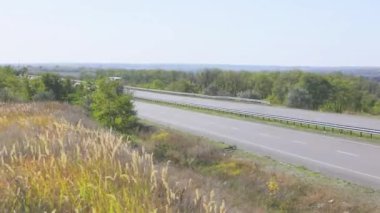 Vagon yazın güzel bir yol boyunca sürer. Bir araba mavi gökyüzüne doğru yol alır
