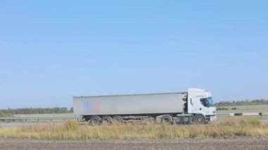 Vagon yazın güzel bir yol boyunca sürer. Bir araba mavi gökyüzüne doğru yol alır