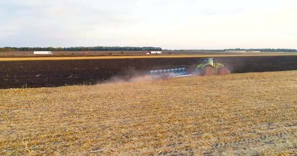 Tractor werkt in het veld bovenaanzicht. Vliegen over de trekker in het veld. De trekker ploegt het veld. — Stockvideo