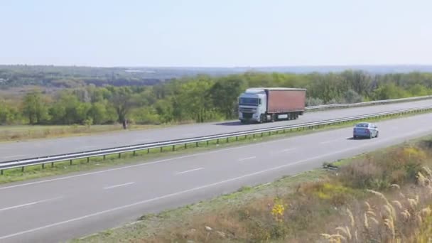 El camión está conduciendo por la carretera. El camión conduce por la carretera alrededor de los campos y árboles — Vídeo de stock