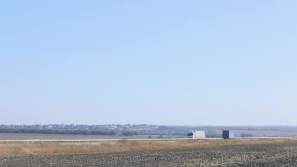 The truck drives on a flat modern road outside the city. The truck is driving along the road on a sunny day — Stock Video