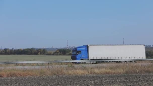 Egy teherautó vezet egy városon kívüli úton, egy modern teherautó vezet egy autópályán. — Stock videók