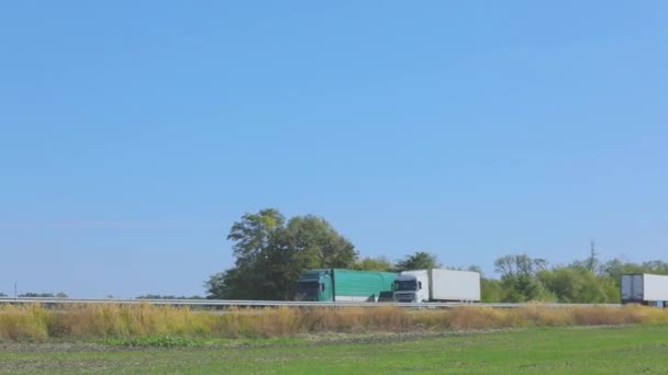 Två lastbilar kör längs vägen bredvid varandra. Lastbilar kör längs motorvägen — Stockvideo