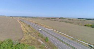 Bir yakıt kamyonu otoban boyunca gidiyor, üst manzara. İHA 'dan yola bir at arabası çıkıyor.
