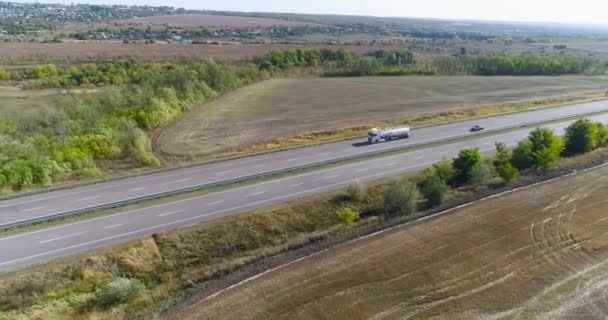 Un chariot roule sur la route depuis un drone. Un camion de carburant roule le long de l'autoroute, vue de dessus. — Video