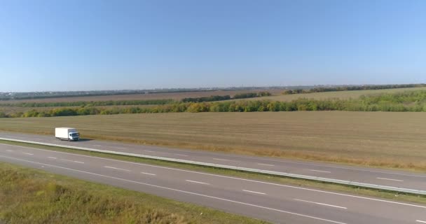 Un camión en la pista en tiempo soleado. El camión está conduciendo a lo largo de una hermosa carretera. Transporte de carga — Vídeos de Stock