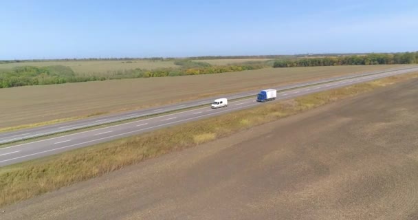 卡车沿着田野疾驰而过.晴天时卡车沿着田野行驶.在美丽的路上开车的卡车 — 图库视频影像