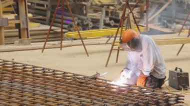 Bir kaynakçı metal bir yapıyı kaynak yapar. Kaynak metal yapımı. Güçlendirilmiş beton takviyesi