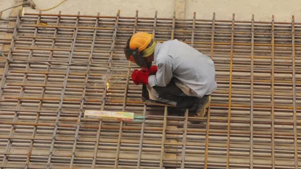 Construcción de marco metálico. Un soldador suelda una estructura metálica. Construcción de metal de soldadura. Refuerzo de hormigón armado — Vídeos de Stock