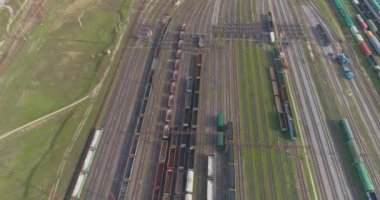 Yük trenleri yukarıdan aşağıya bakıyor. Bir sürü yük treni manzaralı. Tren istasyonunun üzerinde yük trenleriyle uçuyorlar.