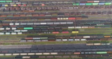 Yük trenleri yukarıdan aşağıya bakıyor. Bir sürü yük treni manzaralı. Tren istasyonunun üzerinde yük trenleriyle uçuyorlar.