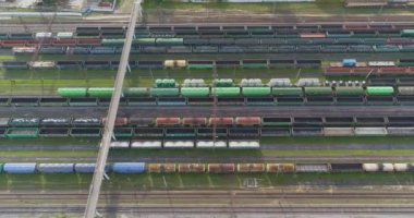 Bir sürü yük treni manzaralı. Yük trenleri yukarıdan aşağıya bakıyor. Tren istasyonunun üzerinde yük trenleriyle uçuyorlar.