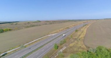 İnsansız hava aracından yola bir at arabası çıkıyor. Yakıt kamyonu otoban boyunca gidiyor..