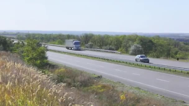 Le camion roule sur l'autoroute autour des champs et des arbres. Le camion roule sur l'autoroute.. — Video