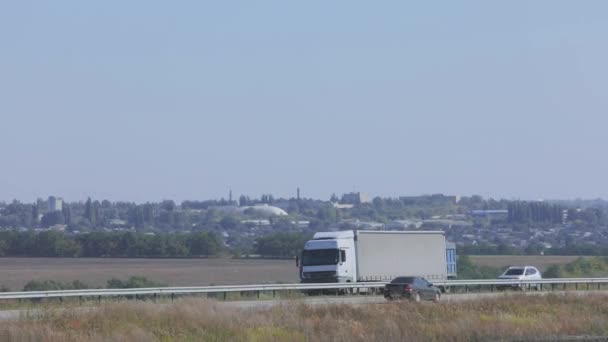 Un vagón blanco conduce a lo largo de la carretera en un clima soleado. Camión en la carretera — Vídeo de stock