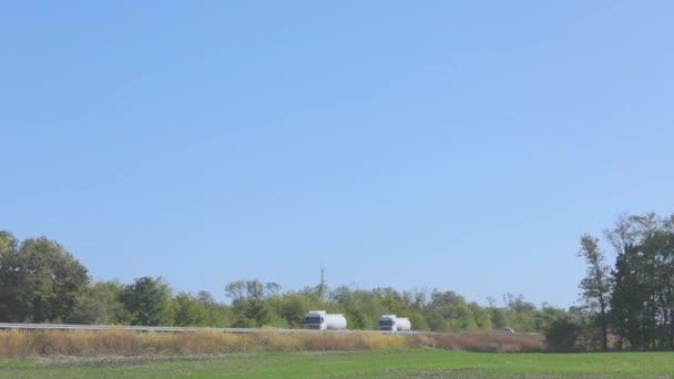 White fuel truck driving along the highway. A fuel truck drives on the highway in good weather — Stock Video