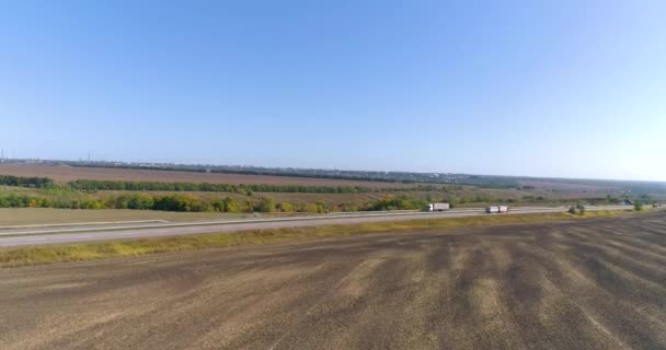 Um camião na pista com tempo ensolarado. O caminhão está dirigindo ao longo de uma bela estrada. Transporte de carga — Vídeo de Stock