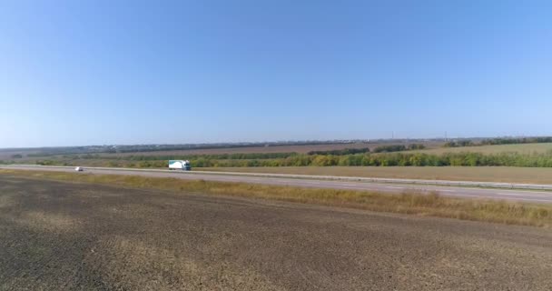 El camión conduce a lo largo de los campos vista superior. Camión conduce a lo largo de los campos en tiempo soleado. Camión conduciendo en una hermosa carretera — Vídeos de Stock