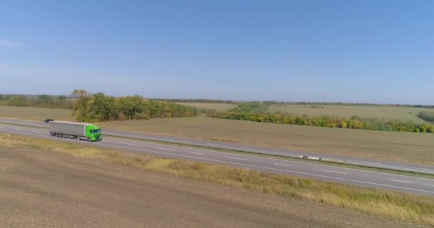 卡车在路上开,田野在后面.3.用卡车运输货物。卡车沿着道路行驶在农田中央，俯瞰景色. — 图库视频影像