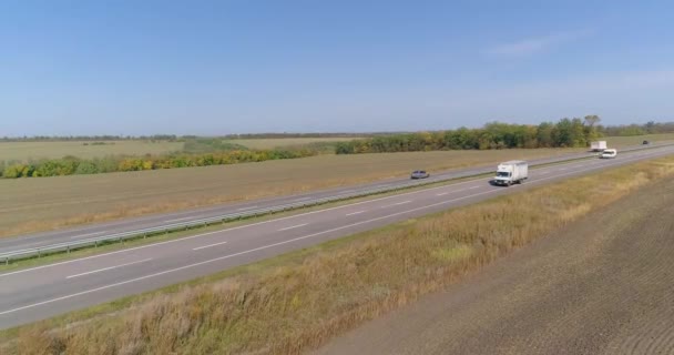 Вантажівка на трасі в сонячну погоду. Вантажівка їде красивою дорогою. Вантажні перевезення — стокове відео