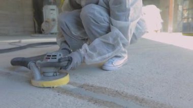 İnşaatçılar zemini özel ekipmanlarla cilalıyorlar. Beton yüzey öğütme. İnşaat alanında inşaatçılar