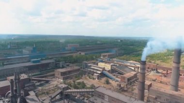 Santralin bacasından tehlikeli emisyonlar. Büyük bir bitkiden duman. Büyük bir metalürjik tesisin üzerinden uçmak. Büyük bitki üst görünümü.