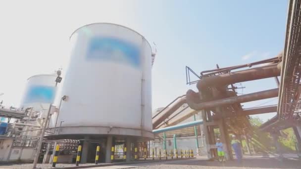 Grandes tanques de almacenamiento en la fábrica. Exterior de una fábrica moderna. Tanques de almacenamiento blancos para líquidos en una fábrica moderna — Vídeos de Stock