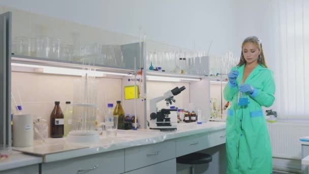 Une fille du laboratoire. Belle fille dans le laboratoire regarde à travers le microscope — Video