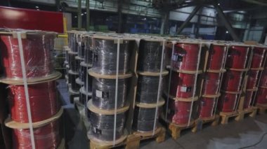 Kablo makaralı paletler. Çeşitli renklerde kaplanmış bakır kablo makaraları. Kablo yapımları