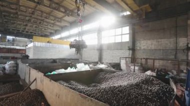 Metal topları olan elektromanyetik vinç, hareket eden elektromanyetik vinçleri olan büyük sanayi binası, top üretimi, bilye üretimi.