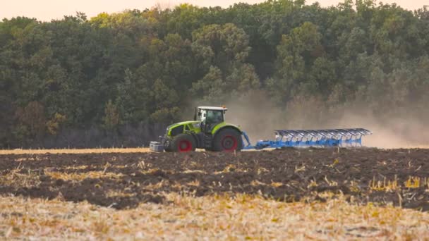 Zielony traktor zaorał pole. Ciągnik w terenie. Nowoczesny traktor orał pole. — Wideo stockowe