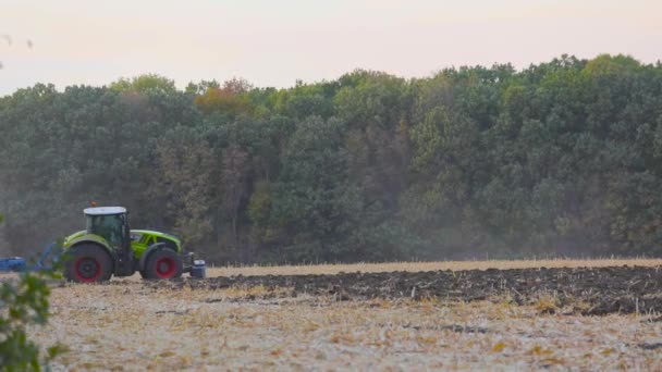Современный трактор работает в поле. Зеленый трактор вспахивает поле. Трактор в поле. Современный трактор вспахивает поле. — стоковое видео