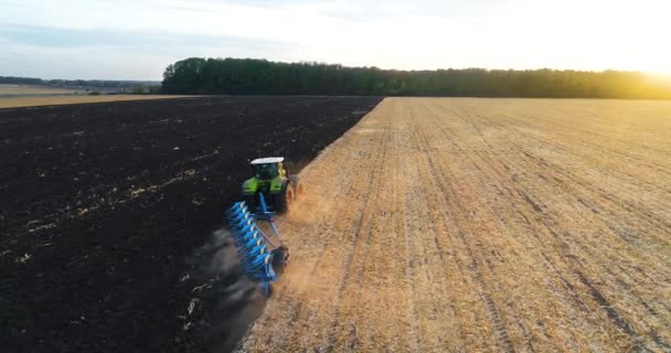 Repül a traktor felett a mezőn. A traktor felülnézetben működik. A traktor felszántja a földet.. — Stock videók